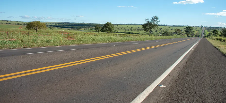 Imagem de uma rodovia federal em Minas Gerais, com pista bem conservada e cenário desértico ao redor, ilustrando investimentos nas rodovias federais na região.
